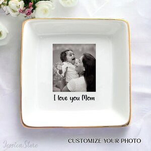 Puede incluir: Bandeja de cer&aacute;mica blanca con borde dorado. La bandeja presenta una foto en blanco y negro de una madre y un ni&ntilde;o. El texto "I love you Mom" est&aacute; impreso debajo de la foto.