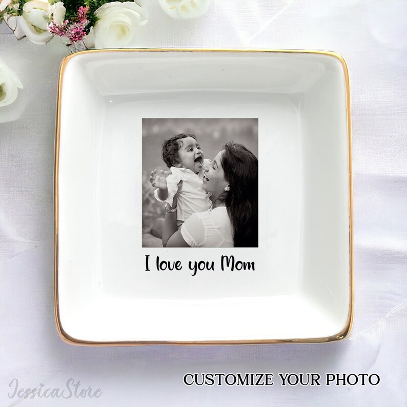 Puede incluir: Bandeja de cer&aacute;mica blanca con borde dorado. La bandeja presenta una foto en blanco y negro de una madre y un ni&ntilde;o. El texto "I love you Mom" est&aacute; impreso debajo de la foto.