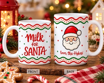 May include: Two white ceramic mugs featuring red and green wavy line patterns. The front mug displays the red text Milk for SANTA. The back mug features a cartoon Santa Claus face and the red text love, the Hykes'.