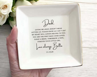 Könnte beinhalten: Ein quadratisches, weißes Keramik-Schmucktablett mit goldenem Rand. Das Tablett trägt eine herzliche Botschaft an einen Vater, darunter die Worte "Dad" und "Love always, Bella". Das Datum "11.13.25" ist ebenfalls eingraviert.