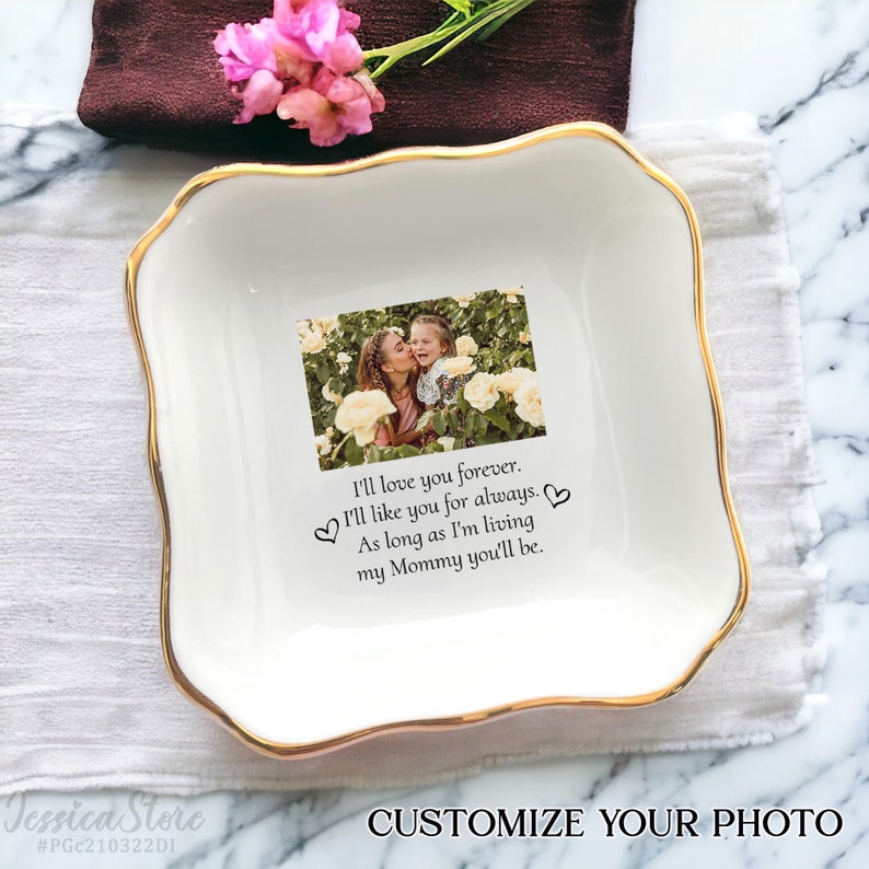 May include: A square white ceramic trinket dish with scalloped edges and a gold-painted rim. The center features a printed photograph of a person kissing a child among yellow roses, with the text: I'll love you forever. I'll like you for always.