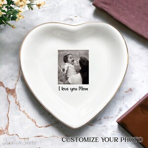 Puede incluir: Plato de cer&aacute;mica blanco en forma de coraz&oacute;n con borde dorado. El plato presenta una foto en blanco y negro de una madre y un hijo con el texto "I love you Mom".