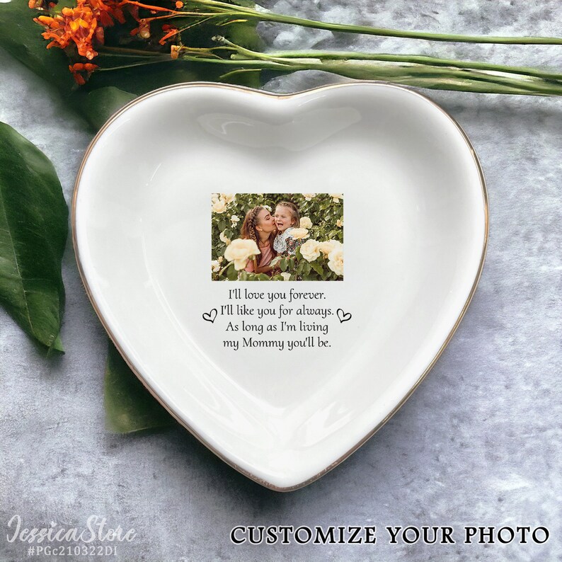 May include: A white heart-shaped ceramic trinket dish featuring a printed photograph of a person kissing a child among yellow roses. Below the photo, the text reads: I'll love you forever. I'll like you for always. As long as I'm living my Mommy you'll be.