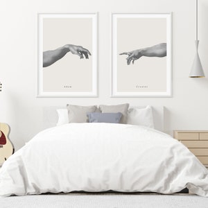 May include: Two black and white framed prints of the Creation of Adam artwork. The left print shows Adam's hand reaching out, with the text "Adam" below. The right print shows God's hand reaching out, with the text "Creator" below.