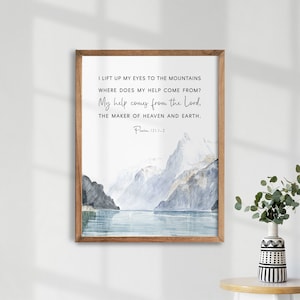 Könnte beinhalten: Ein Aquarellgemälde von Bergen und einem See mit einem Zitat aus Psalm 121,1-2: "Ich hebe meine Augen auf zu den Bergen, woher kommt mir Hilfe? Meine Hilfe kommt vom Herrn, der Himmel und Erde gemacht hat."