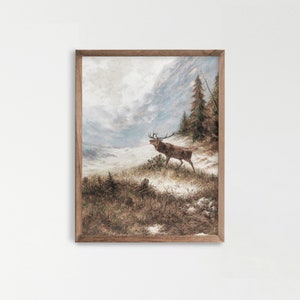 Può includere: Un dipinto incorniciato di un cervo in piedi in un paesaggio montano innevato. Il cervo è marrone con grandi corna e guarda a sinistra. Lo sfondo è una catena montuosa nebbiosa con alcuni alberi.