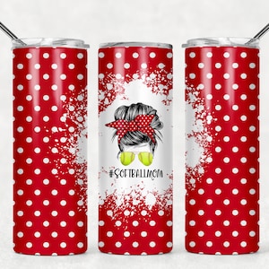 Op de afbeelding: Een rode en witte stippenbeker met een wit splatterontwerp en een afbeelding van een vrouw met een knot, zonnebril en een softbal. De tekst "#SOFTBALLMOM" staat onder de afbeelding.