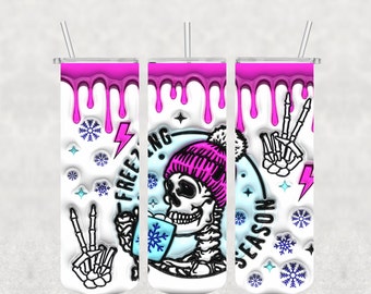 Puede incluir: Tres vasos blancos con un diseño de goteo rosa. El vaso del centro presenta un esqueleto con un gorro rosa con un pompón y sosteniendo una taza azul con un copo de nieve. El texto "Freezing Season" está en el vaso. El vaso de la izquierda tiene una mano de esqueleto con dos dedos levantados en señal de paz. El vaso de la derecha tiene una mano de esqueleto con dos dedos levantados en señal de paz.