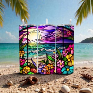 May include: Three stainless steel tumblers with a colorful stained-glass design of a beach scene with flowers, sun, and waves. Each tumbler has a clear lid and a straw. The tumblers are on a sandy beach.