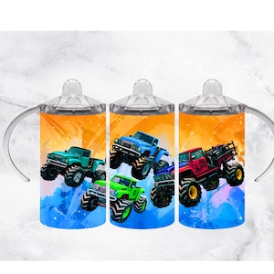 Op de afbeelding: Drie tuitbekers met kleurrijke monstertruckontwerpen. Elke beker heeft een andere truck in teal, blauw, groen en rood, tegen een levendige oranje en blauwe achtergrond. De bekers hebben doorzichtige deksels en witte handvatten.
