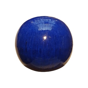 Peut inclure: Un objet sphérique brillant de couleur bleu profond. La surface réfléchit la lumière, créant des reflets. L'objet semble être fait d'un matériau solide, peut-être de la céramique ou du verre. La forme générale est une sphère parfaite.