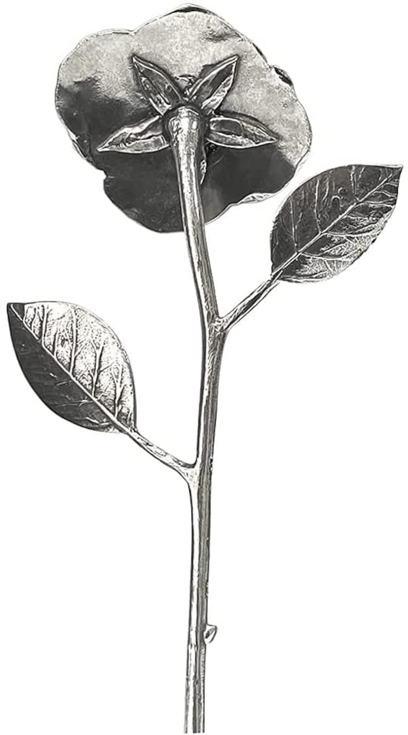May include: A silver metal flower sculpture with a single bloom and leaves. The flower is facing down and the stem is long and slender.