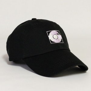 May include: Black baseball cap with a white embroidered design of a record with the number 80 on it.