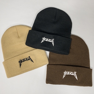May include: Three knit beanies in black, brown, and beige with the word "YEEZY" embroidered in white on the front of each beanie.
