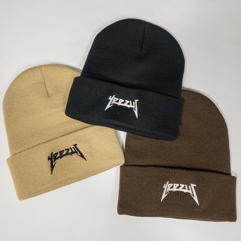 May include: Three knit beanies in black, brown, and beige with the word "YEEZY" embroidered in white on the front of each beanie.