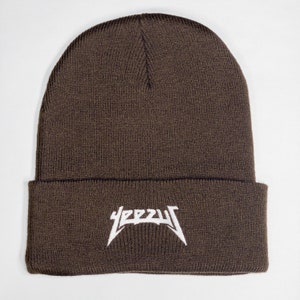 May include: A brown knitted beanie with a white "YEEZY" logo embroidered on the front.
