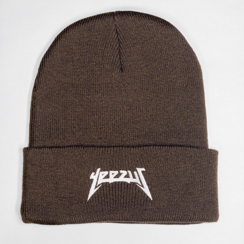 May include: A brown knitted beanie with a white "YEEZY" logo embroidered on the front.