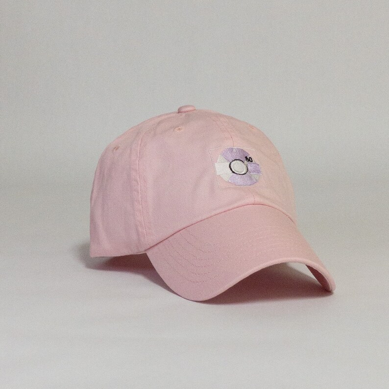 May include: A pink baseball cap with a white and purple embroidered record design on the front. The record has the number "30" on it.