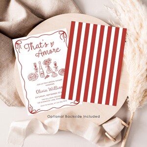 May include: A red and white striped card with the text "That's Amore" in red script. The card is a bridal shower invitation with a hand-drawn illustration of food and wine.