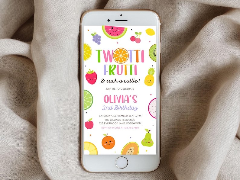 May include: A smartphone displays a colorful birthday invitation. The design features the words "TWOTTI FRUTTI" with fruit illustrations like watermelon, grapes, and kiwi. The invitation is for Olivia's 2nd birthday, with date, time, and location details.
