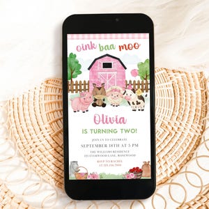 May include: A smartphone displays a farm-themed birthday invitation. The design features a pink barn, cartoon animals, and the text "oink baa moo." The invitation reads "Olivia is turning two!" and includes event details.