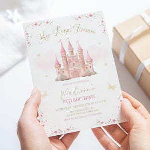 May include: A pink and gold invitation card with the text "Her Royal Fiveness" and "Madison's 5th Birthday". The card features a pink castle illustration and floral accents. A gift box is in the background.