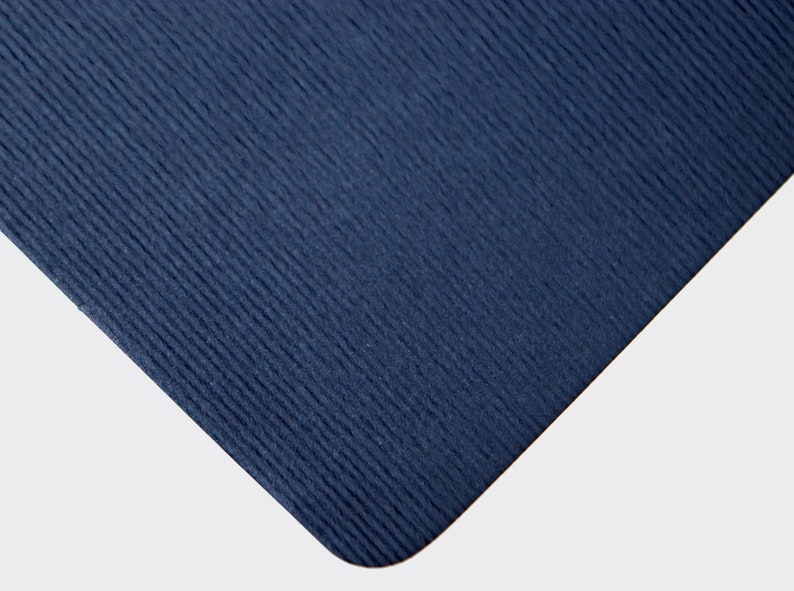 May include: A close-up of a dark blue yoga mat with a textured surface.
