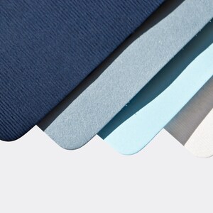 May include: Four pieces of cardstock in shades of blue, gray, and white. The cardstock is arranged in a fan shape, with the darkest blue at the top and the lightest white at the bottom.