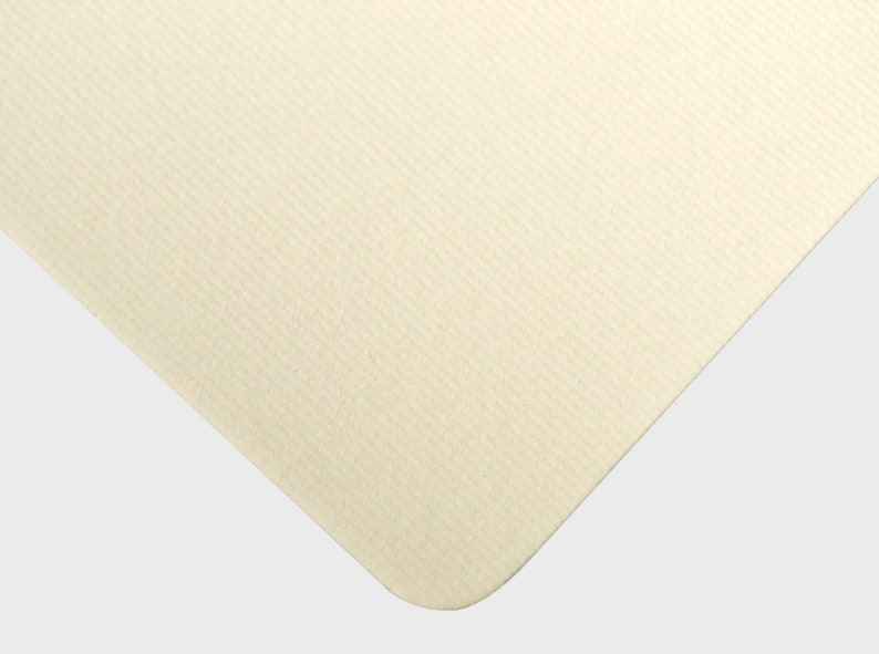 May include: A close-up of a cream-colored textured surface. The surface has a subtle, fine grain pattern.