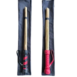 May include: Two black canvas bags with leather handles, each containing a wooden cane with a red and black leather wrapped handle.