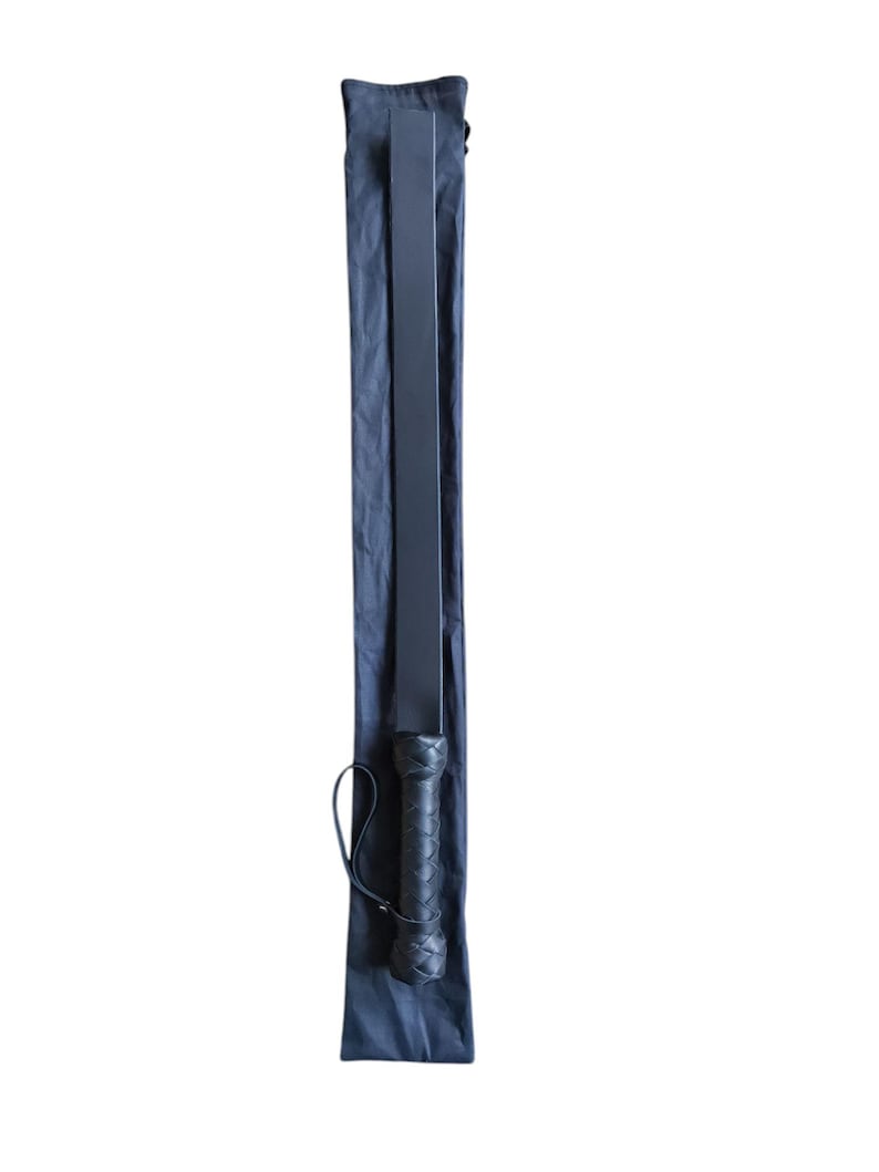 May include: A black leather paddle with a braided handle, in a black fabric carrying case.