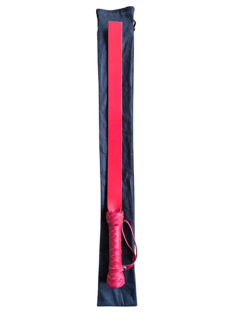 May include: A red leather paddle with a braided handle, in a black carrying bag.