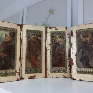 Pode incluir: Quatro painéis de madeira com detalhes em folha de ouro, cada um com uma imagem emoldurada de uma mulher em estilo art nouveau vintage. Os painéis são dispostos lado a lado, criando um biombo decorativo ou um divisor de ambientes.