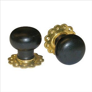 May include: Two black wooden door knobs with gold metal rosettes. The rosettes have a decorative scalloped edge.