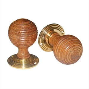 May include: Two wooden door knobs with brass accents. The knobs are round and have a ribbed design.