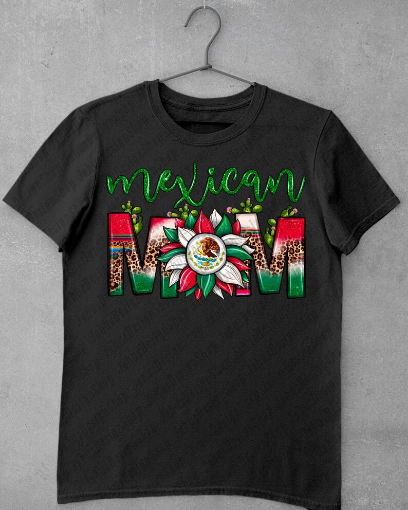 May include: Black t-shirt with the words "Mexican MOM" in a colorful design. The word "Mexican" is in green script, and "MOM" features a floral design with the Mexican flag and cactus accents.