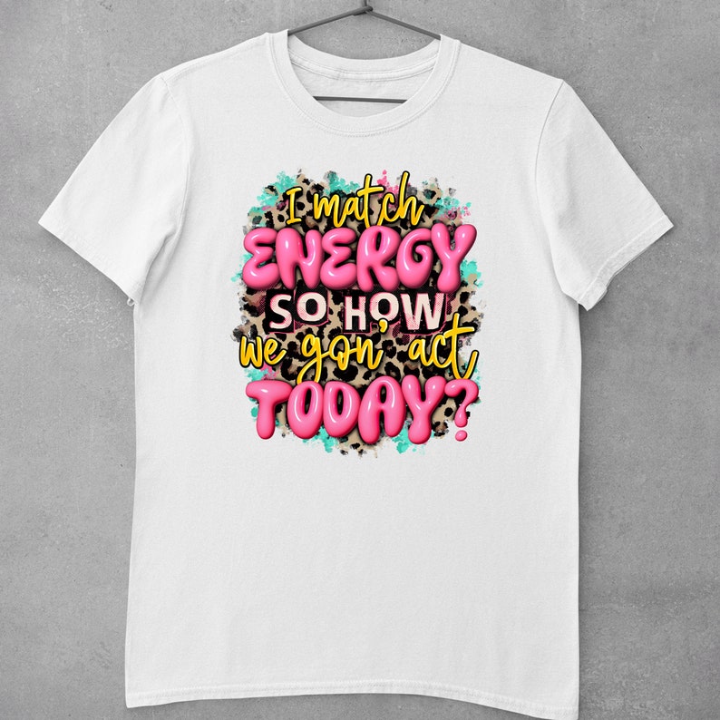 May include: White t-shirt with a pink and black graphic print that says "I match energy so how we gon act today?"