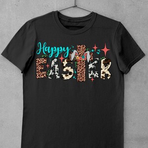 May include: Black t-shirt featuring the text "Happy Easter" in colourful letters with animal print patterns and a bunny rabbit with floral accents.