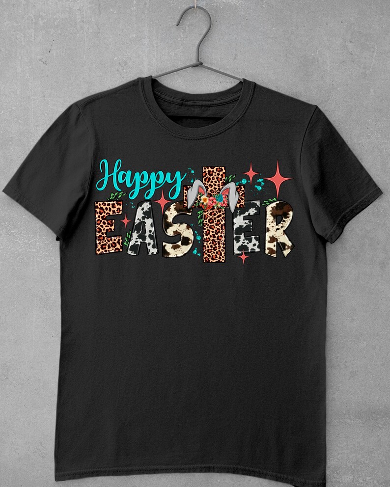 May include: Black t-shirt featuring the text "Happy Easter" in colourful letters with animal print patterns and a bunny rabbit with floral accents.