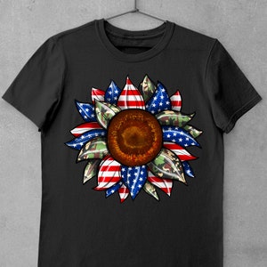 May include: Black t-shirt with a sunflower design. The sunflower is made up of red, white, and blue stripes, and green camouflage print.