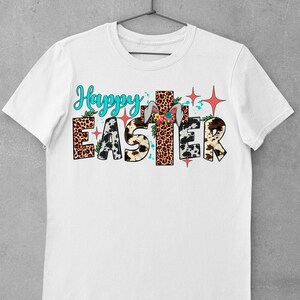 May include: White t-shirt with the text "Happy Easter" in colourful letters with animal print patterns and a cross behind the word "Easter".