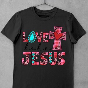 May include: Black t-shirt with a pink and black plaid cross and the words "LOVE like JESUS" in pink and black with turquoise accents.