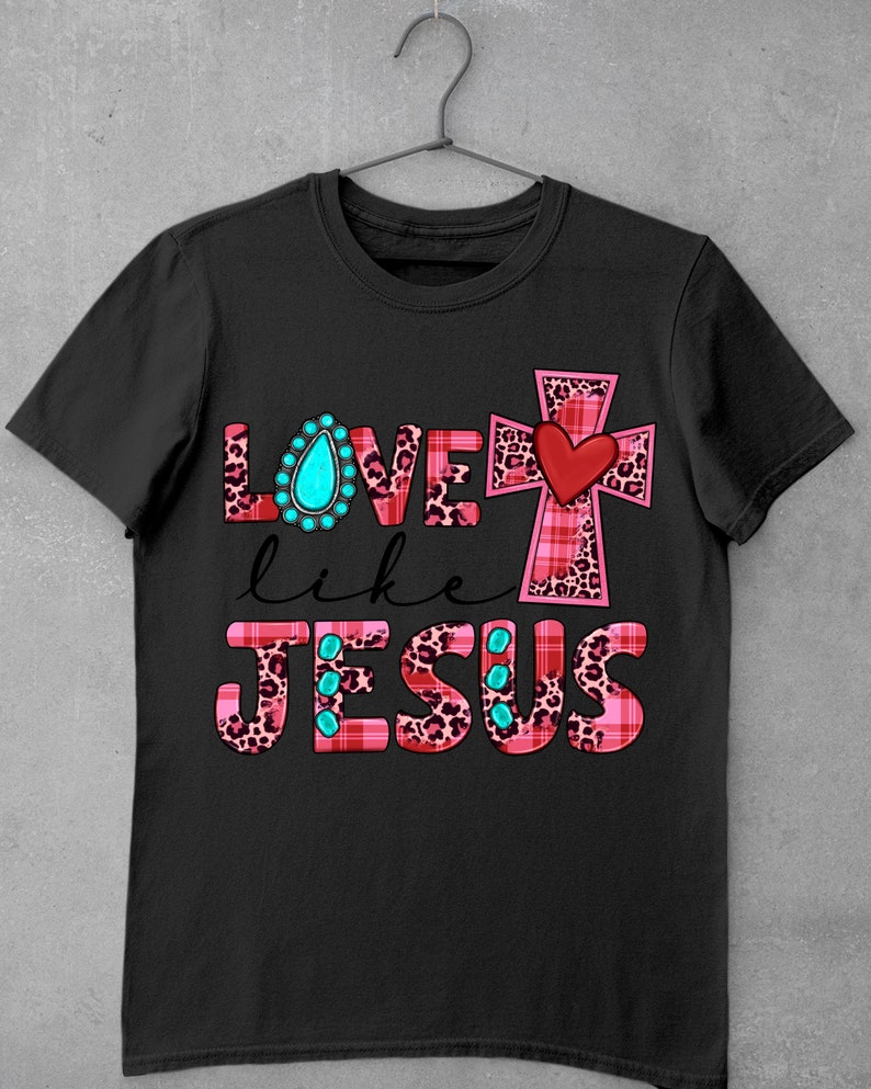 May include: Black t-shirt with a pink and black plaid cross and the words "LOVE like JESUS" in pink and black with turquoise accents.