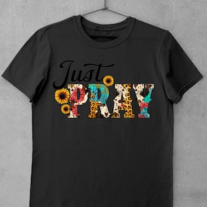 May include: Black t-shirt with the text "Just Pray" in colorful letters with a floral and animal print design.