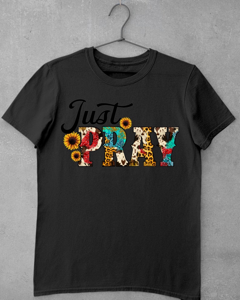 May include: Black t-shirt with the text "Just Pray" in colorful letters with a floral and animal print design.