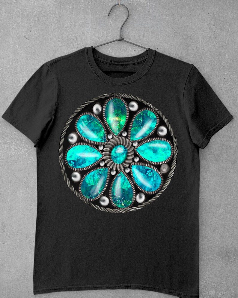 Op de afbeelding: Zwart T-shirt met een cirkelvormig ontwerp in turquoise en zilver met een bloemvormig patroon met meerdere turquoise stenen.