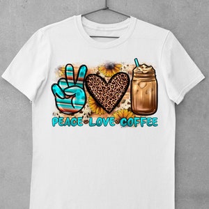May include: White t-shirt with a peace sign, heart, and iced coffee graphic. The peace sign is blue and red, the heart is leopard print, and the coffee is in a mason jar with a straw. The text "Peace Love Coffee" is below the graphic.