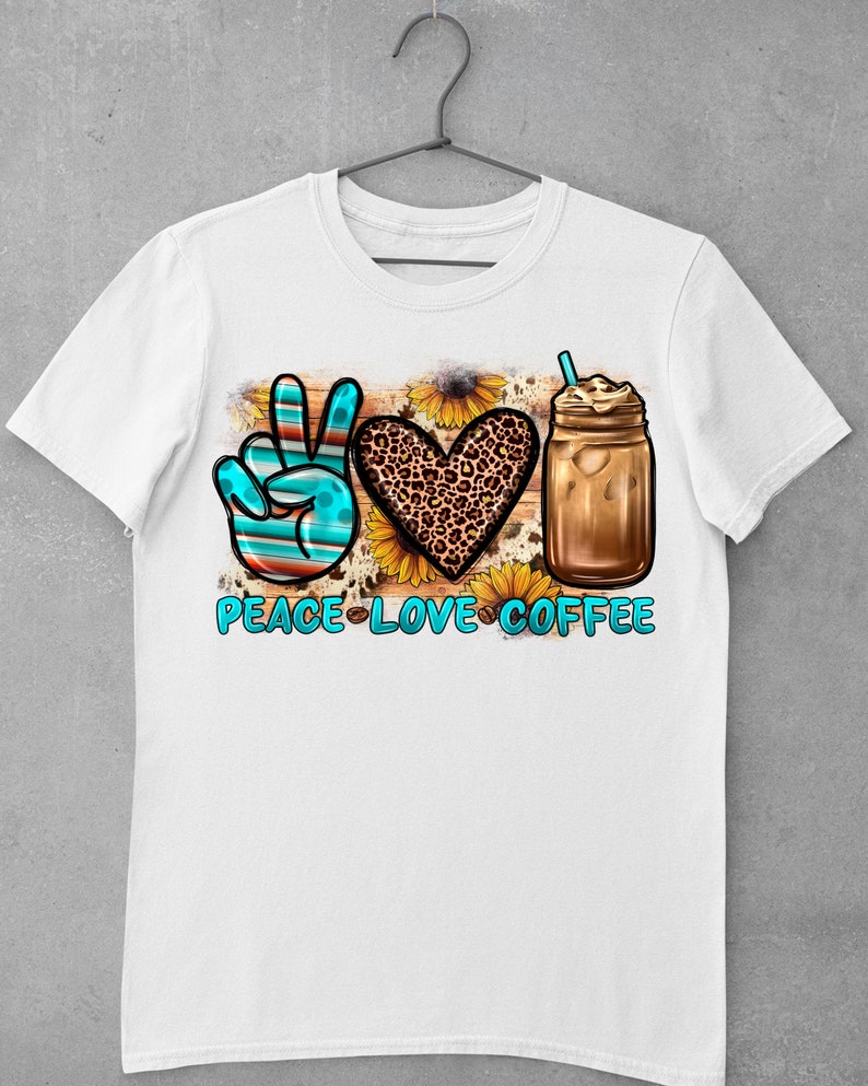 May include: White t-shirt with a peace sign, heart, and iced coffee graphic. The peace sign is blue and red, the heart is leopard print, and the coffee is in a mason jar with a straw. The text "Peace Love Coffee" is below the graphic.