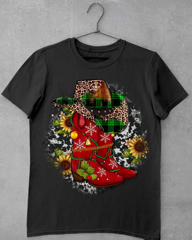 May include: Red cowboy boots with green and black plaid and leopard print accents, decorated with snowflakes, holly, and jingle bells. The boots are on a white and black cowhide background.