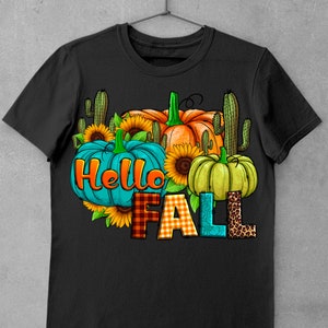 May include: Black t-shirt with a graphic design featuring pumpkins, sunflowers, and cacti. The text "Hello Fall" is written in colorful letters.
